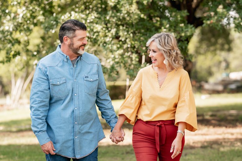 Troy and Leanna Brewer walking together outdoors, holding hands.